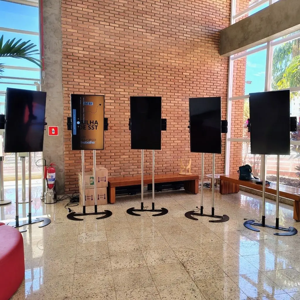 Múltiplas telas de TV em pedestal no lobby do SESI em Ribeirão Preto